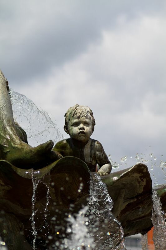 eine Kinderfigur an einem Brunnen