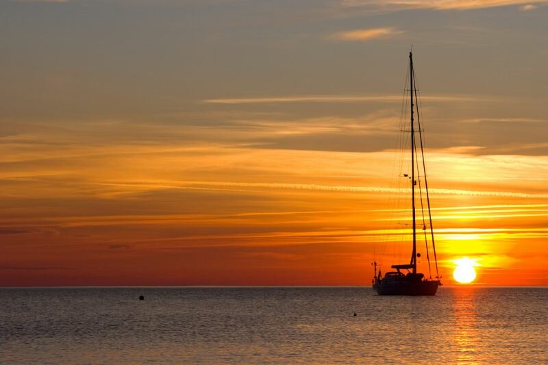 ein Segelboot vor untergehender Sonne