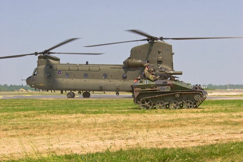 Militärfahrzeug der Bundeswehr mit Hubschrauber im Hintergrund (CH-47 Transporthubschrauber und Wiesel)